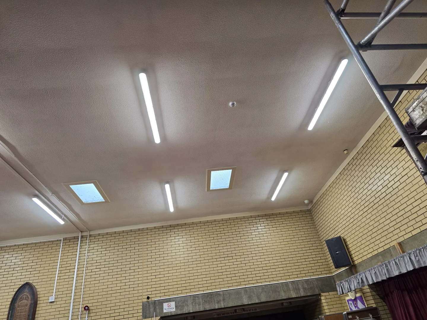 Illuminated linear ceiling lights in a large hall