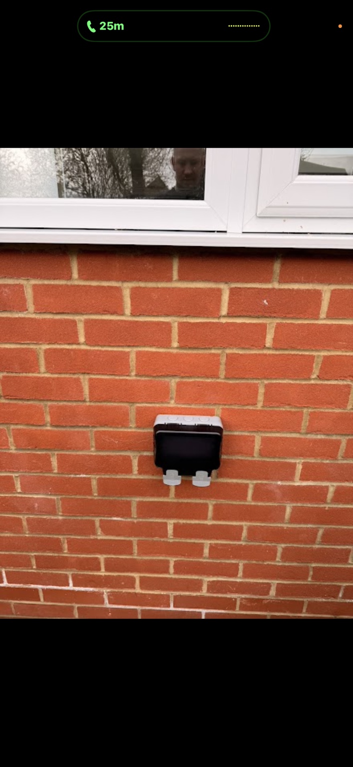 Weatherproof outdoor socket on a brick wall